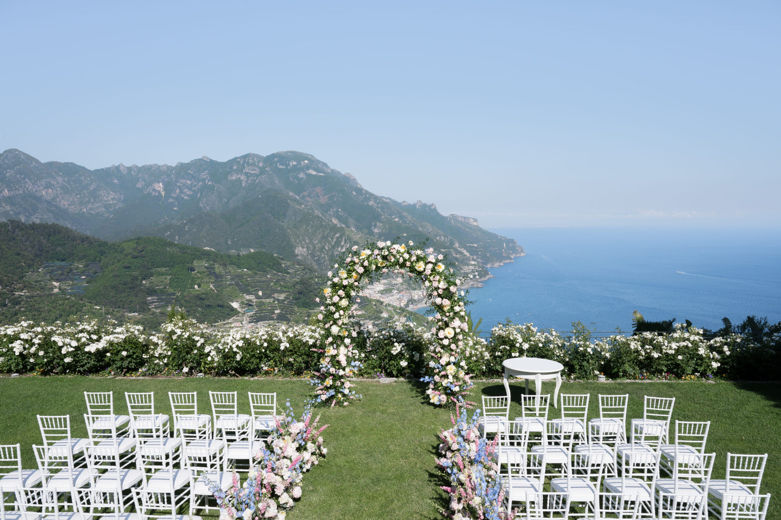 A flower wedding setup on the terrace of Belmond Hotel Caruso, perched atop the cliffs of Ravello